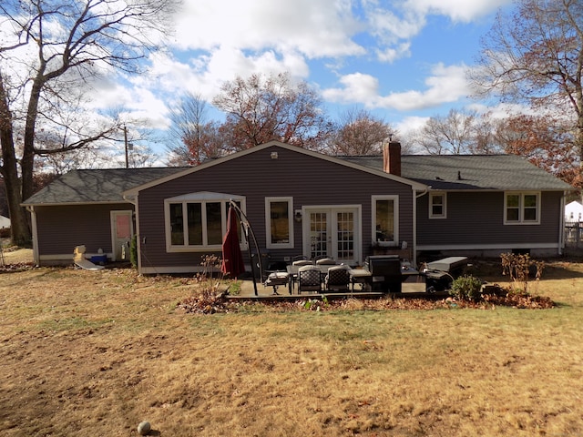 rear view of property featuring a lawn, outdoor lounge area, a patio, and french doors