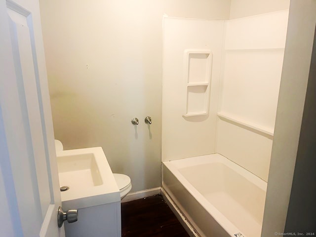 bathroom featuring hardwood / wood-style floors, vanity, a bath, and toilet