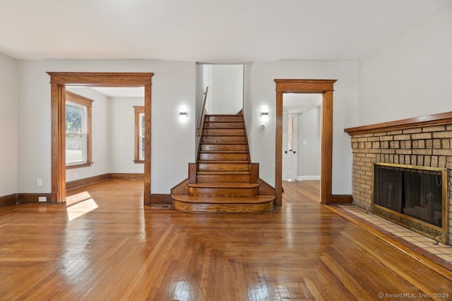 unfurnished living room with parquet floors and a fireplace