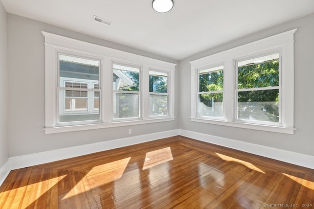 unfurnished room featuring hardwood / wood-style floors and a wealth of natural light