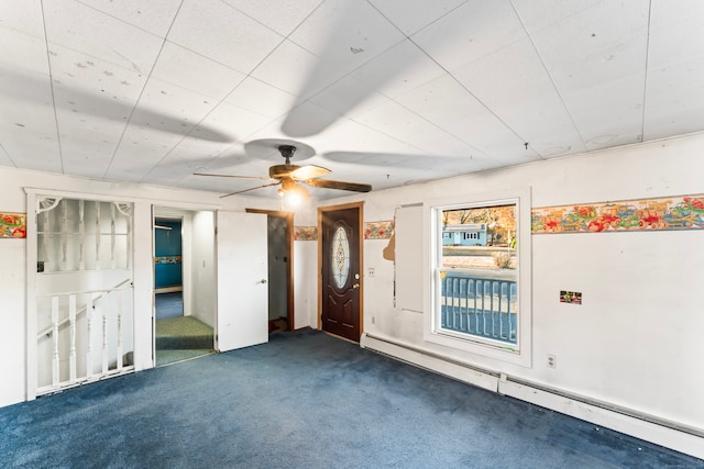 carpeted empty room with baseboard heating and ceiling fan