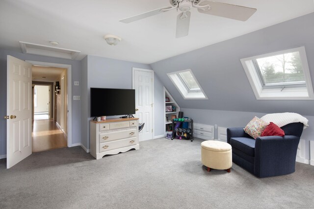 living area featuring lofted ceiling with skylight, plenty of natural light, carpet, and ceiling fan