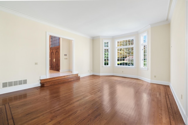 empty room featuring hardwood / wood-style floors and ornamental molding