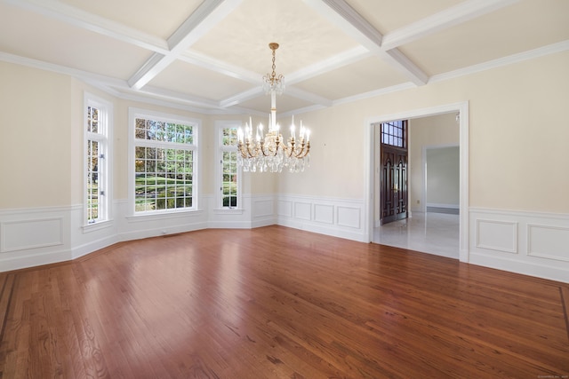 unfurnished dining area with coffered ceiling, beam ceiling, wood-type flooring, and a chandelier