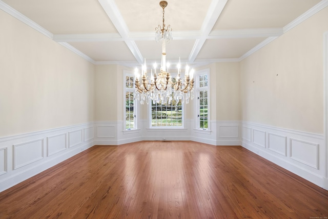 unfurnished dining area with a chandelier, beam ceiling, hardwood / wood-style flooring, and ornamental molding