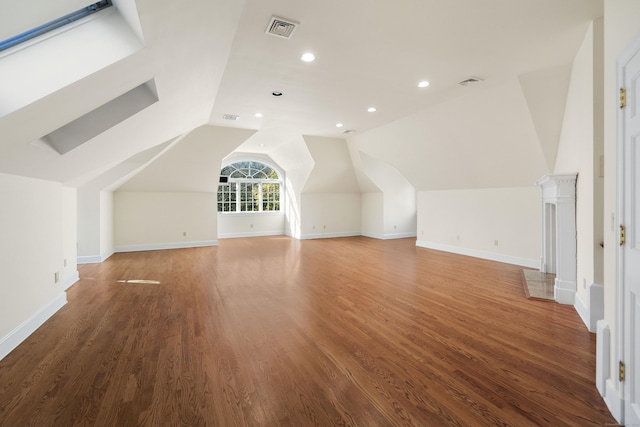 additional living space with wood-type flooring and lofted ceiling