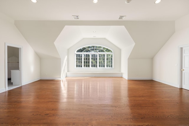 bonus room with hardwood / wood-style floors and vaulted ceiling