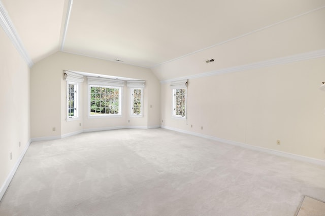 empty room featuring light colored carpet and lofted ceiling