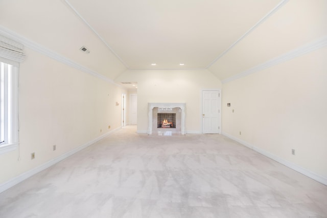 unfurnished living room featuring crown molding, a high end fireplace, light colored carpet, and lofted ceiling