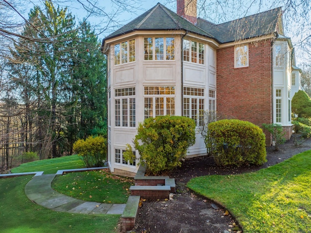 rear view of property featuring a lawn