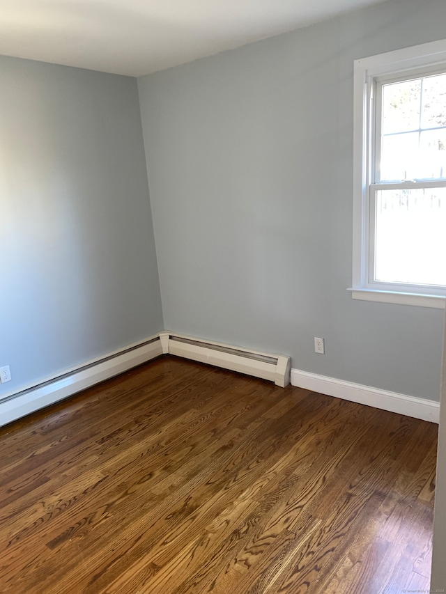 unfurnished room featuring wood-type flooring and a baseboard radiator