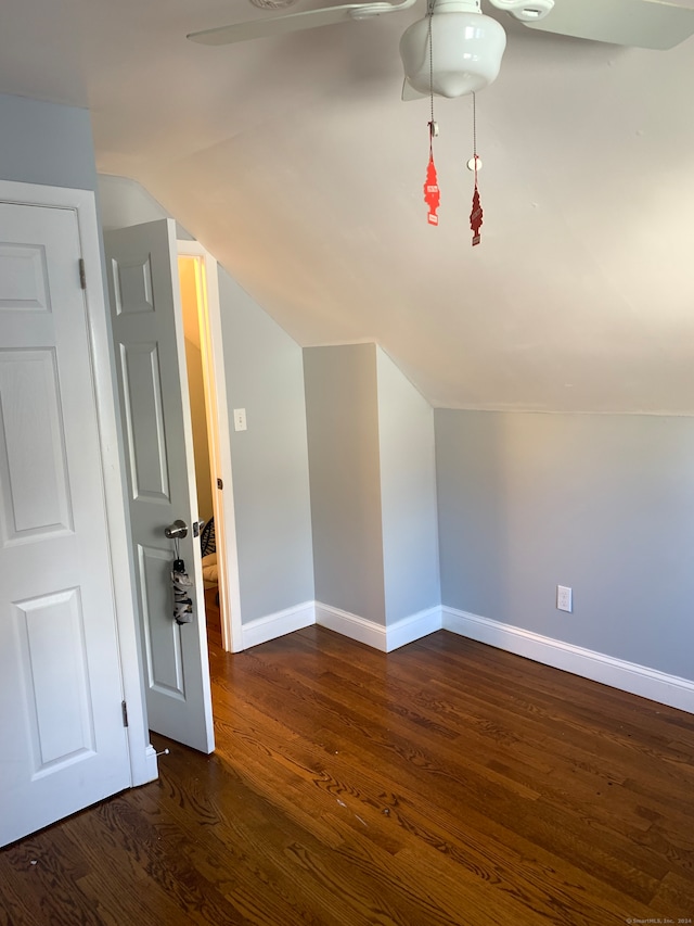 bonus room with dark wood-type flooring and vaulted ceiling