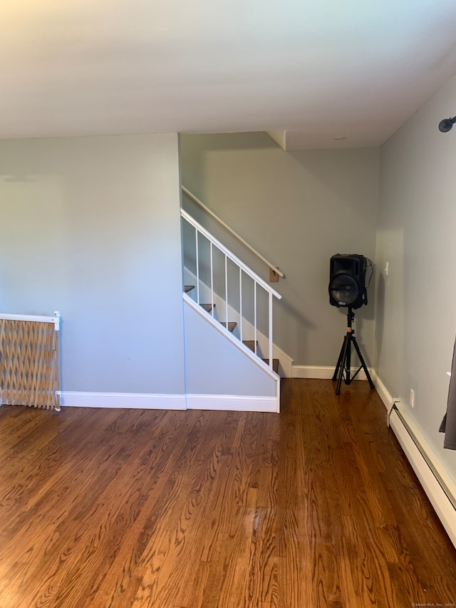 staircase featuring hardwood / wood-style floors and baseboard heating