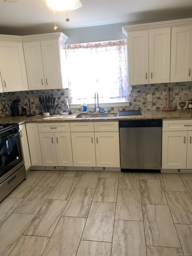 kitchen with backsplash, stone counters, white cabinets, sink, and appliances with stainless steel finishes