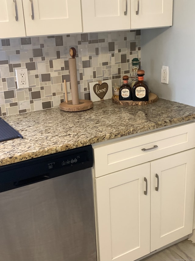 kitchen featuring backsplash, white cabinetry, dishwasher, and light stone counters