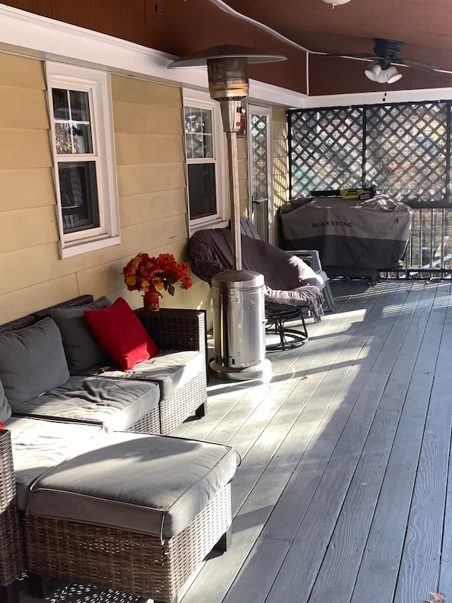 deck featuring area for grilling and ceiling fan