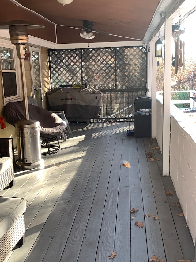 wooden deck with area for grilling and ceiling fan