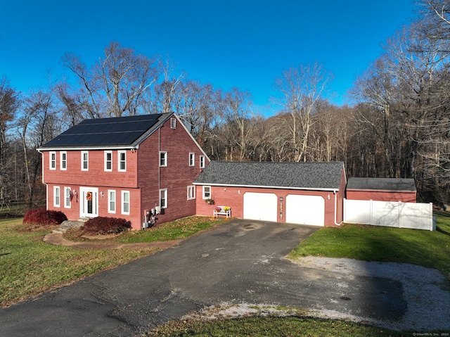 view of home's exterior featuring a lawn, a garage, and solar panels