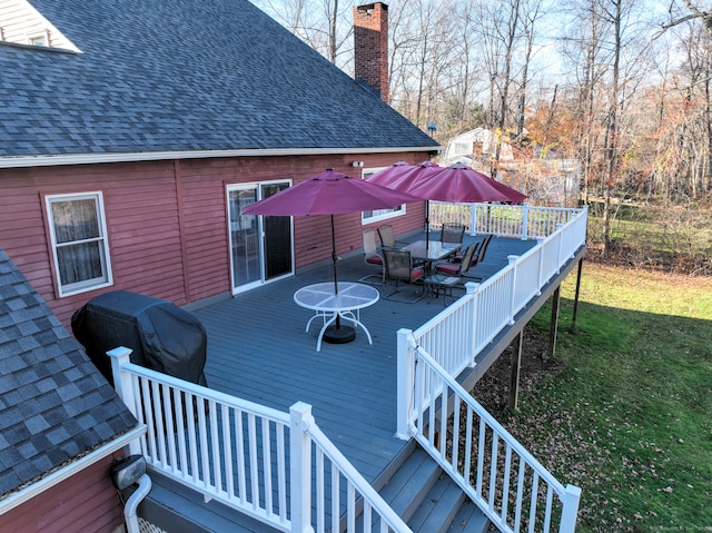 wooden deck featuring a lawn