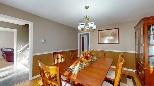 dining space featuring light hardwood / wood-style floors and a notable chandelier