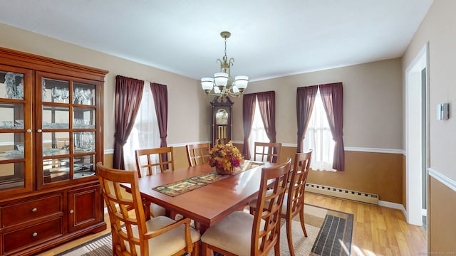 dining room featuring a baseboard radiator, a notable chandelier, and light wood-type flooring