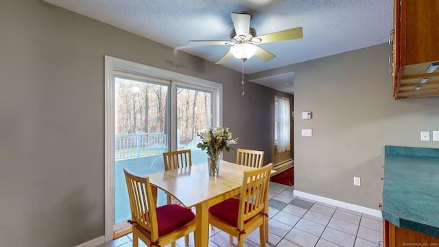 tiled dining room featuring ceiling fan, a textured ceiling, and a baseboard heating unit