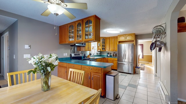 kitchen featuring sink, stainless steel appliances, kitchen peninsula, a textured ceiling, and light tile patterned flooring