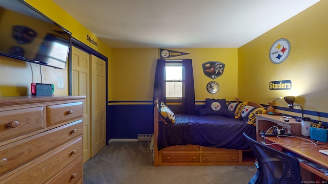 carpeted bedroom with a closet and baseboard heating