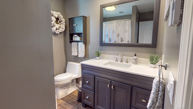 bathroom with hardwood / wood-style flooring, vanity, and toilet