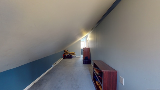 additional living space with carpet, vaulted ceiling, and a baseboard heating unit