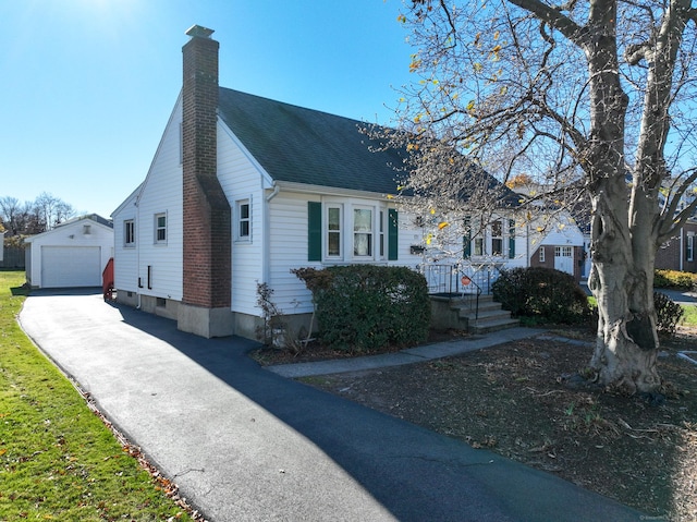 view of front of house with a garage and an outbuilding