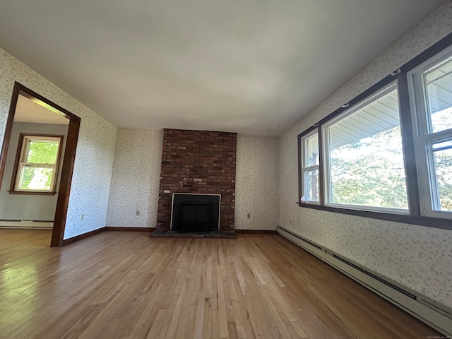 unfurnished living room with a fireplace, light hardwood / wood-style flooring, and a baseboard radiator