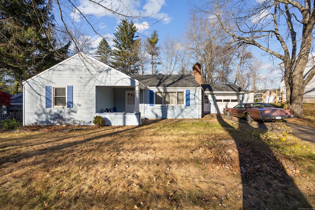 single story home featuring a garage and a front lawn