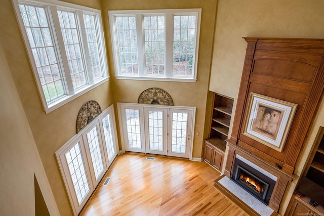 living room with light wood-type flooring and a towering ceiling