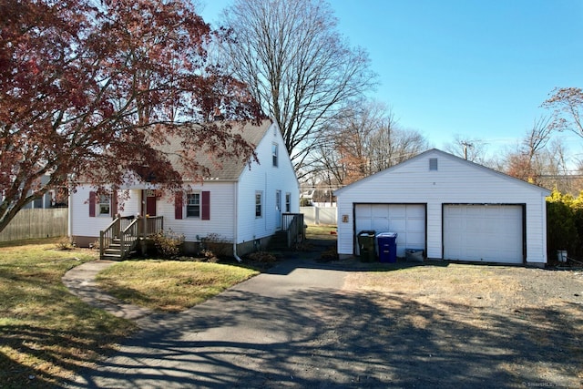 view of front facade featuring an outbuilding, a garage, and a front yard