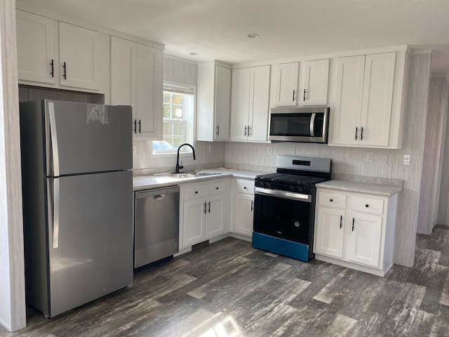 kitchen featuring appliances with stainless steel finishes, dark hardwood / wood-style flooring, and white cabinetry