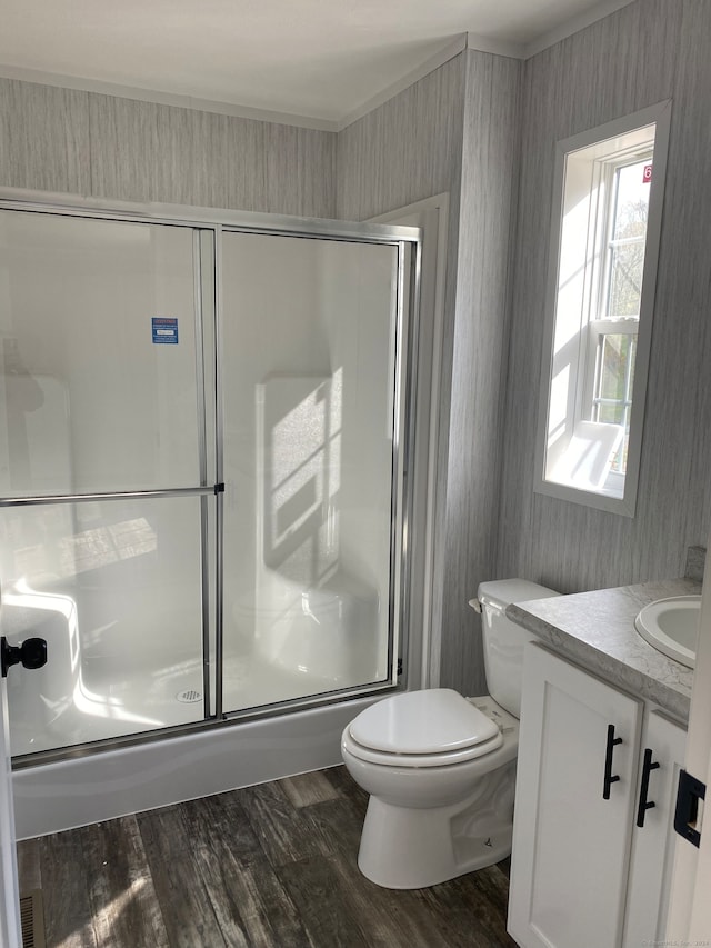 full bathroom featuring shower / bath combination with glass door, toilet, vanity, and hardwood / wood-style flooring