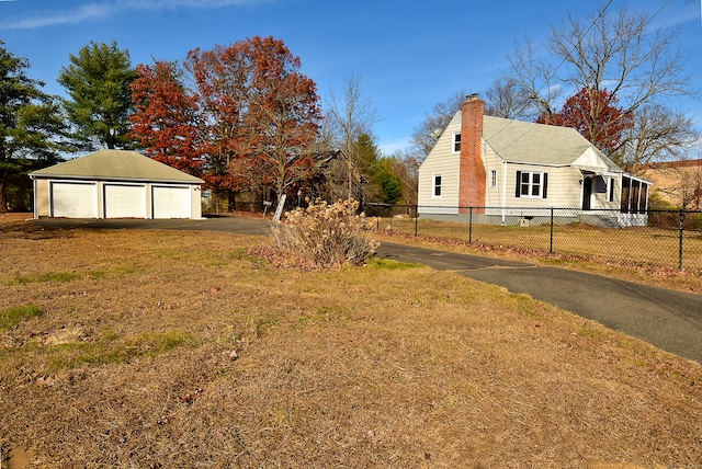 view of property exterior featuring a garage, a yard, and an outbuilding