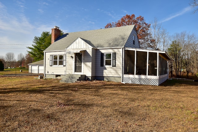 view of front of house with a front lawn and a sunroom