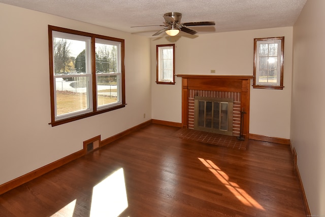 unfurnished living room with plenty of natural light, dark wood-type flooring, and a textured ceiling