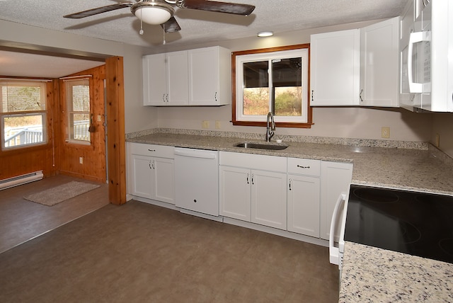 kitchen featuring white cabinets, white appliances, wood walls, and sink