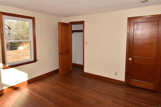 unfurnished bedroom featuring a textured ceiling and dark wood-type flooring