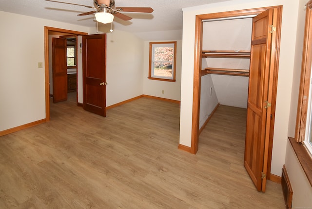 unfurnished bedroom featuring a closet, a textured ceiling, light hardwood / wood-style floors, and ceiling fan