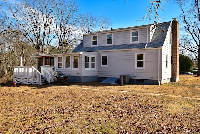 back of house featuring a sunroom, a deck, a yard, and central air condition unit