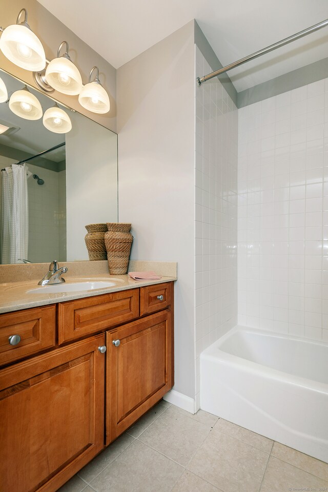 bathroom featuring tile patterned flooring, vanity, and shower / bath combo with shower curtain