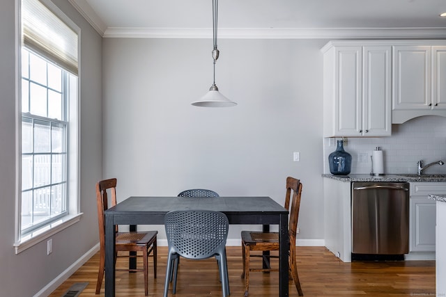 dining area featuring plenty of natural light, dark wood-type flooring, and ornamental molding