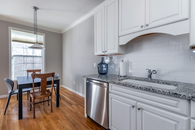 kitchen featuring dishwasher, sink, white cabinets, and hardwood / wood-style floors