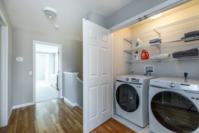 clothes washing area with hardwood / wood-style flooring and independent washer and dryer