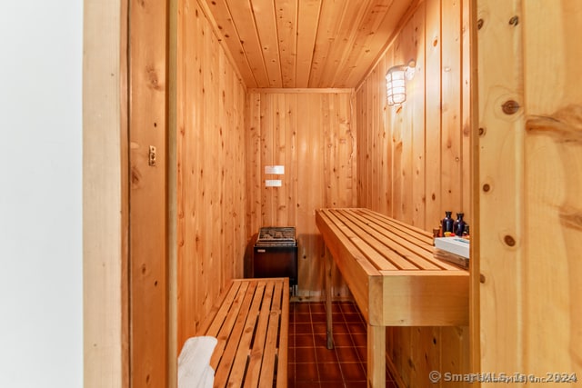 view of sauna with tile patterned flooring, wooden walls, and wood ceiling