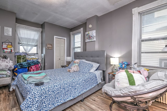 bedroom featuring hardwood / wood-style floors and a textured ceiling